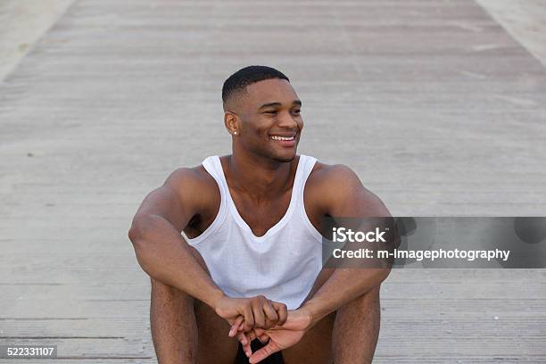 Cool Guy Smiling And Sitting Outdoors Stock Photo - Download Image Now - 20-24 Years, 20-29 Years, Adult