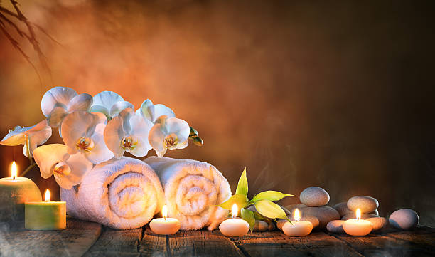 Spa - Couple Towels With Candles And Orchid Two Towels, Bamboo, candles and pebble of Stones For Natural Massage indulgence photos stock pictures, royalty-free photos & images