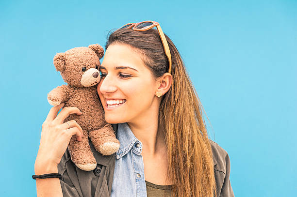 istock Young woman with small vintage teddy bear on her shoulder 522332627
