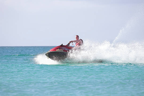 istock Young guy cruising the caribbean sea on a jet ski 522332837
