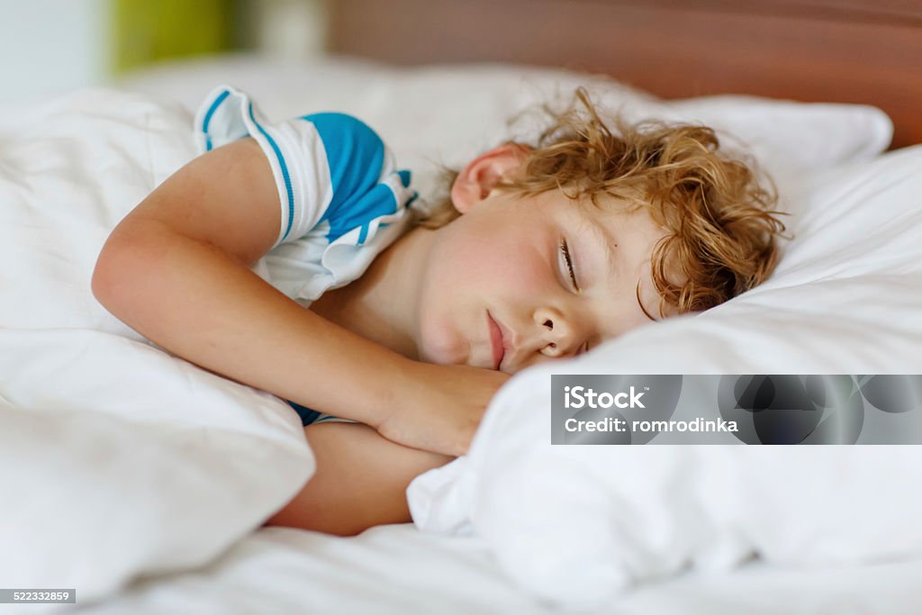 Little blond boy sleeping in his bed. Little blond boy sleeping in his bed Sleeping Stock Photo
