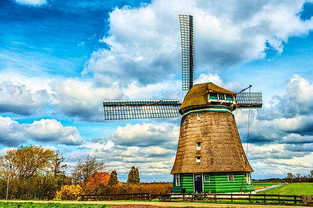 традиционный голландский ветряная мельница на типичном канал в нидерландах - polder windmill space landscape стоковые фото и изображения