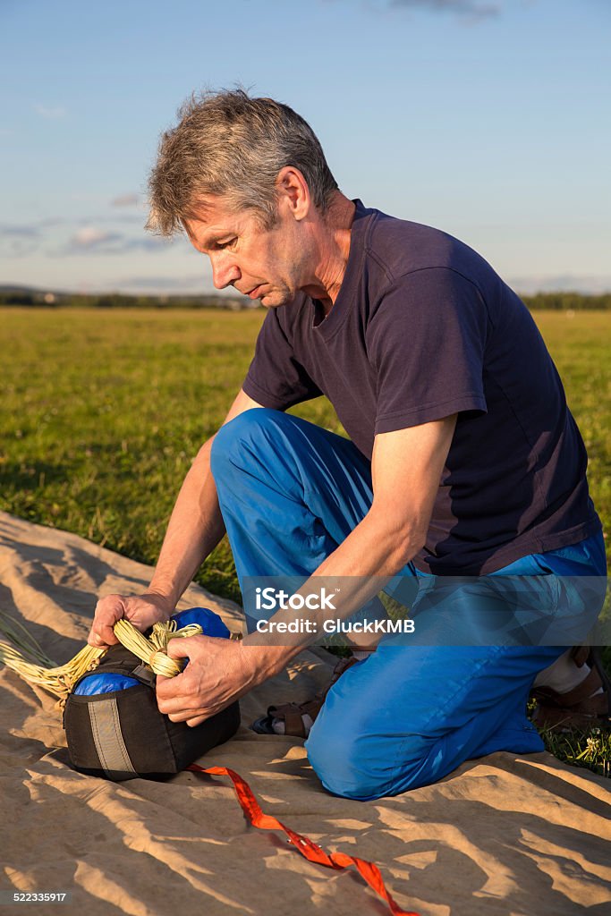 man puts on the parachute sling man puts on the parachute sling on field Activity Stock Photo