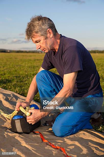 Man Puts On The Parachute Sling Stock Photo - Download Image Now - Activity, Adult, Agricultural Field