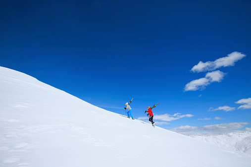 Winter sport  friends men and women snow skiers carrying skis