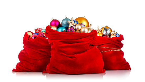 Three Santa Claus red bags with Christmas toys on white background.