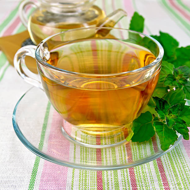istock Tea with mint in cup and teapot on tablecloth 522347365