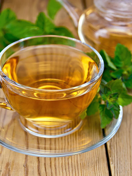 istock Tea with mint in cup and teapot on wooden board 522347369
