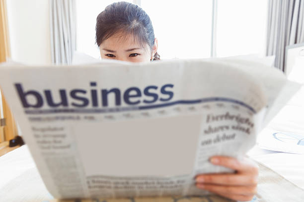 istock asian businesswoman reading newspaper 522354543