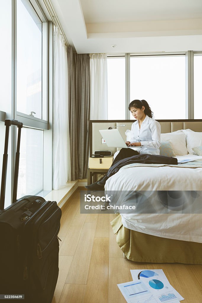 Businesswoman working on her laptop in the bed asian businesswoman working on her laptop in the bed, business trip on road in hotel. 20-24 Years Stock Photo