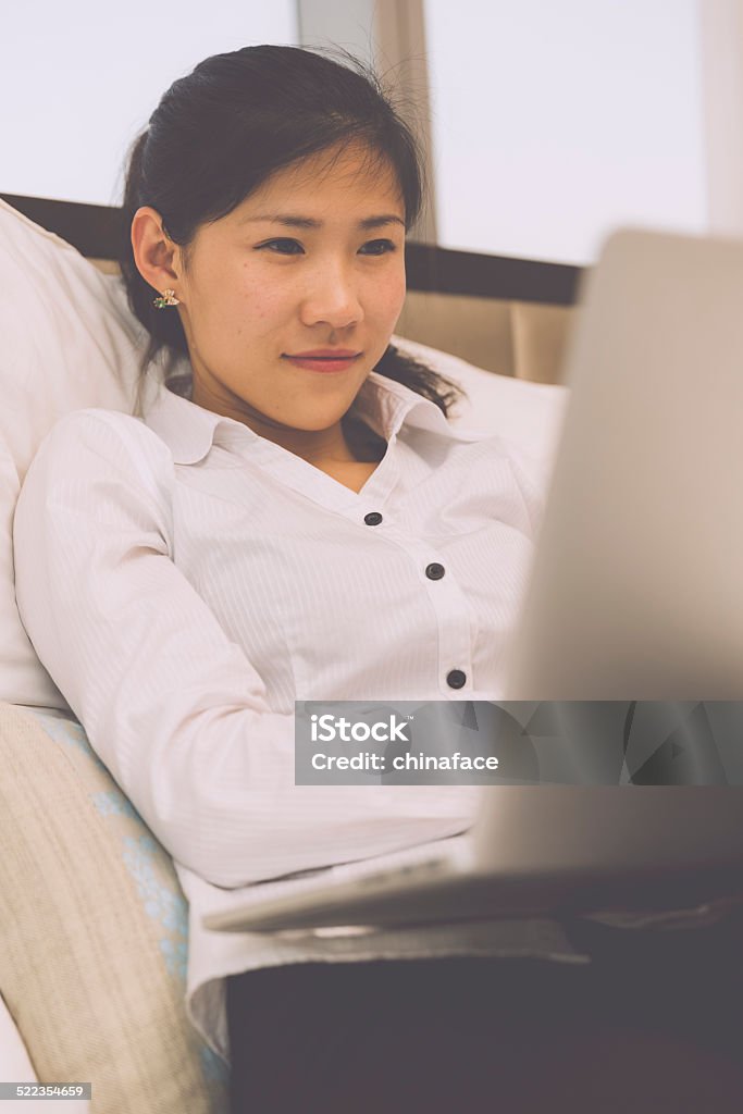 Businesswoman working on her laptop in the bed asian businesswoman working on her laptop in the bed, business trip on road in hotel. 20-24 Years Stock Photo