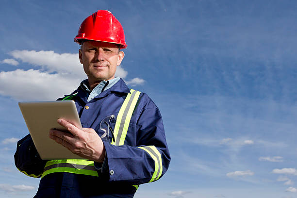 голубой воротник работник, используя планшетный компьютер - mining engineer oil industry construction site стоковые фото и изображения