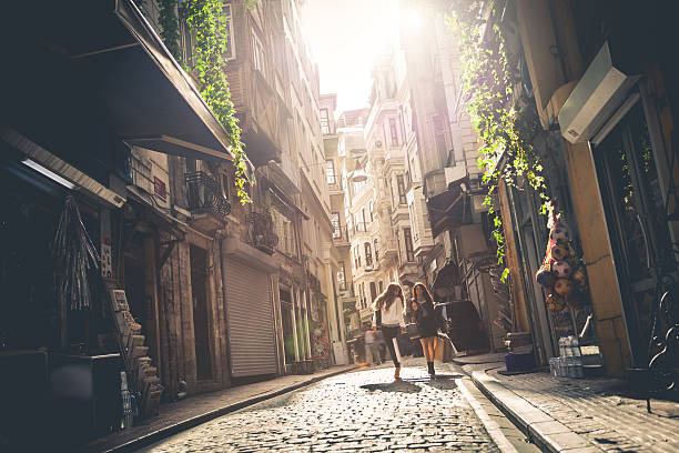 Two friends walking in the city streets doing shopping in downtown.