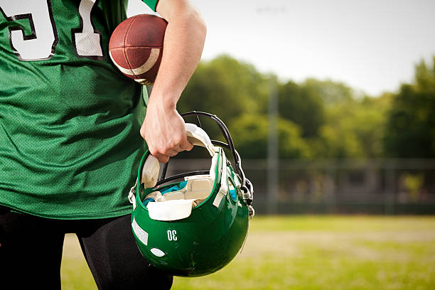 amrtican football-spieler hält helm und ball close-up - football player american football athlete sport stock-fotos und bilder