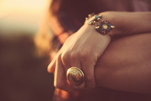 Close-up image of a woman's hand, wearing a fashionable vintage oriental ring and a bracelet. Shot in pastel, cross processed tones of film emulation, with Canon full frame camera EOS 5d mark 2 with large aperture zoom lens Sigma 28-75 at f2,8 with only natural light.