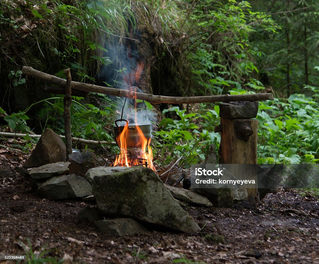 Campfire Camping kettle over burning campfire Activity Stock Photo