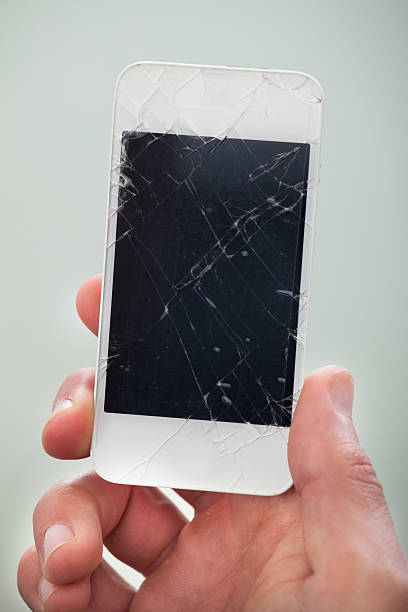 istock Businessman holding a damaged smartphone 522360469