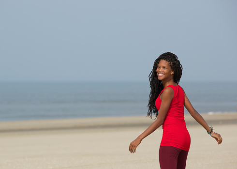 Portrait of a smiling african american woman walking at the beach