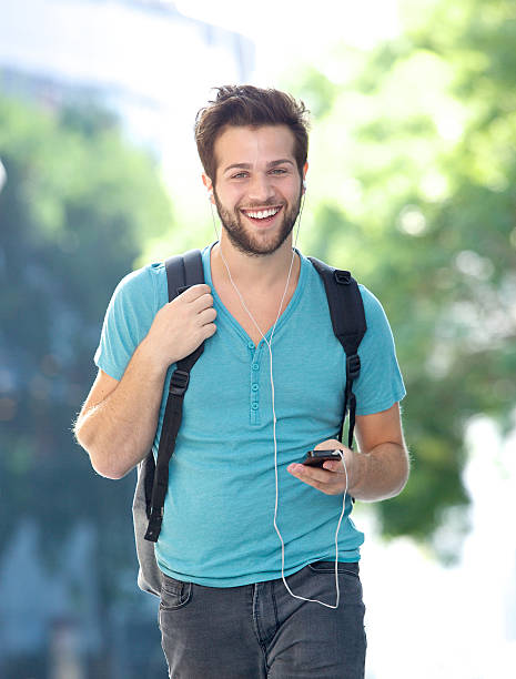 istock Happy young man walking outdoors with cellphone 522360937