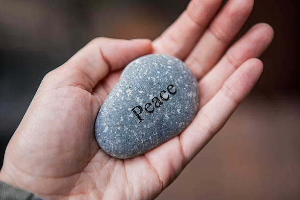 istock Inner balance concept: hands holding stones with the word peace 522368366