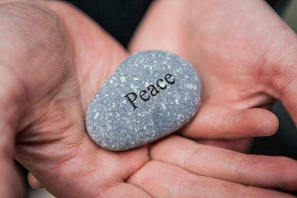 istock Inner balance concept: hands holding stones with the word peace 522368382