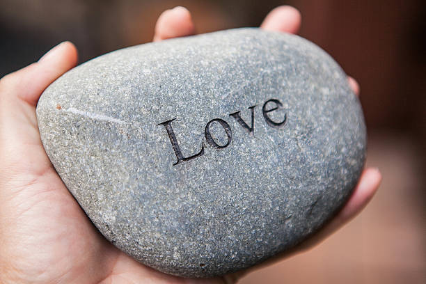 istock Inner balance concept: hands holding stones with the word love 522368478