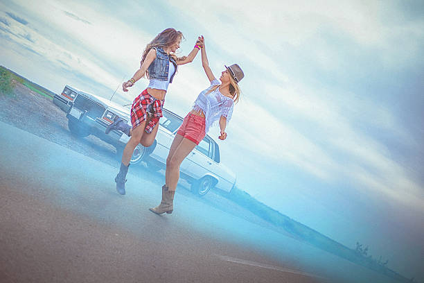 istock Two young women dancing on the road and sharing moment 522368752