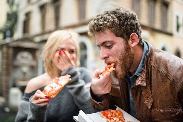 istock couple eating a pizza in italy 522369060