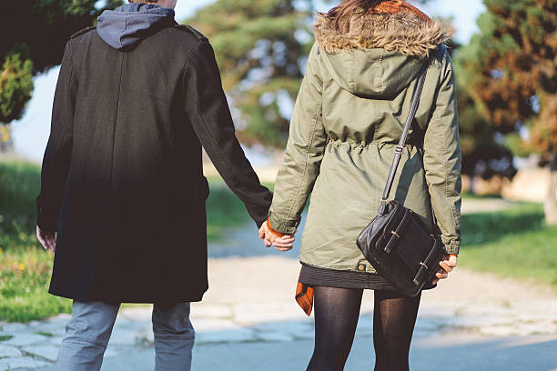 joven pareja caminando juntos en el parque - couple old fashioned hipster holding hands fotografías e imágenes de stock