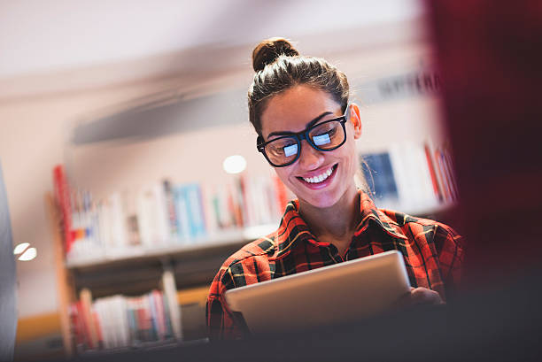 mulher jovem em seu escritório - woman with glasses reading a book imagens e fotografias de stock