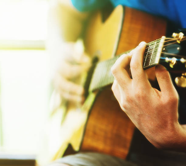 istock Acoustic guitar being played in front of a bright window 522373192