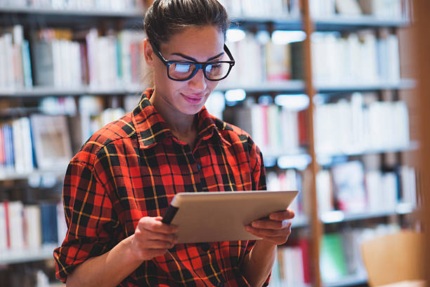 jovem mulher na biblioteca - nerd student female exam - fotografias e filmes do acervo