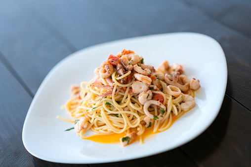 Spaghetti with Mixed Raw Seafood in a Plate by the Sea.