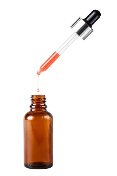 Brown medicine glass bottle with dropper and red liquid inside over white background