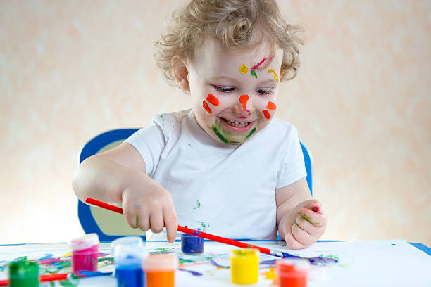 istock Cute little child painting 522377383