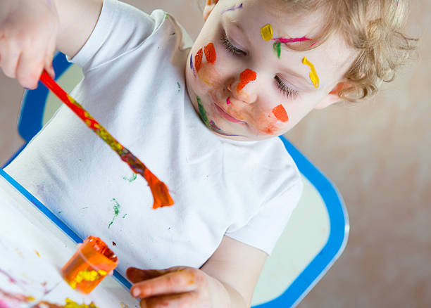 istock Cute little child painting 522377385