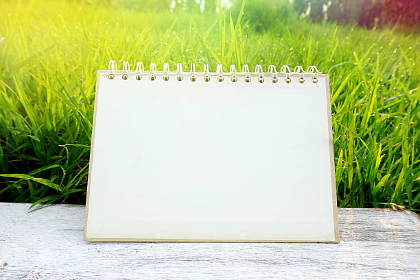 Old notebook on grass. Visible spots on paper.