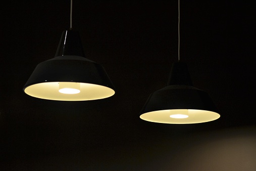 Two lighted pendant lamps in a dark room.