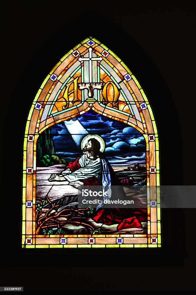 Stained Glass Of Jesus In Century Old Church Stained glass window of Jesus praying in the Garden of Gethsemane found in a century old church. Stained Glass Stock Photo