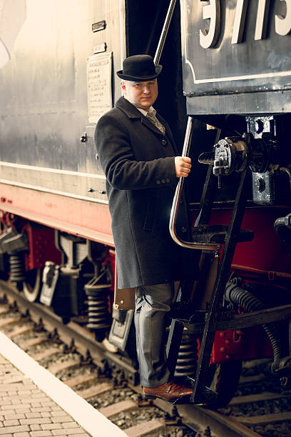 istock man in retro suit and bowler hat getting in train 522384002