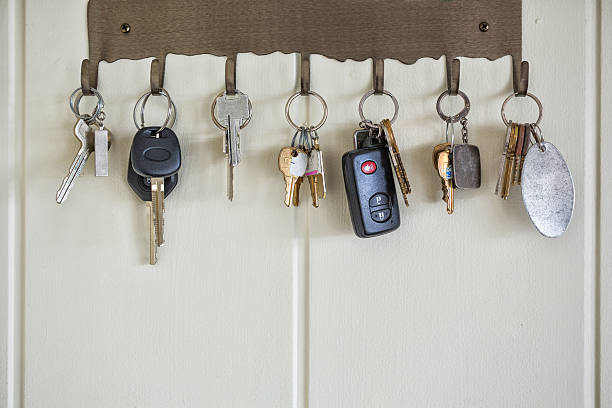 Several types of keys hanging on wall hooks stock photo