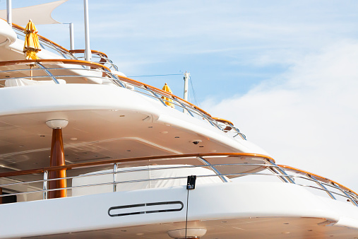 Closeup side view of white luxury yacht agains sky, full frame horizontal composition with copy space