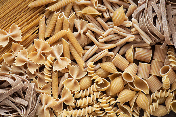 Variety of wholemeal pasta Variety of types and shapes of wholemeal pasta. Dry integral pasta background whole wheat stock pictures, royalty-free photos & images