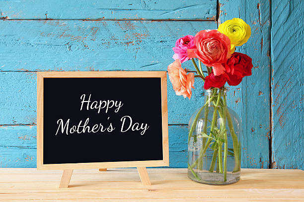 istock flowers next to blackboard, on wooden table 522388144