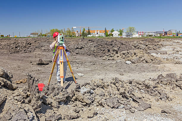 istock Female geodesist is working with total station on building site. 522388830