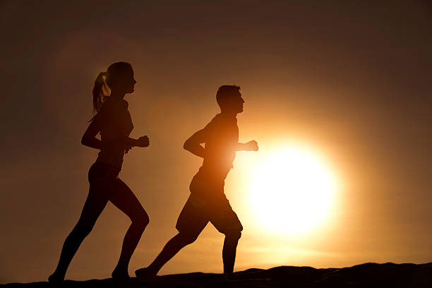 istock Silhouette couple run together on a sunset 522395316