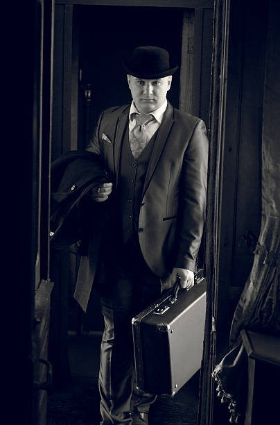 istock man in bowler hat with suitcase walking in the train 522395964