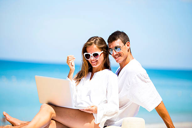 Summer couple using laptop stock photo