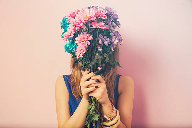 Young attractive beautiful woman smelling flowers. stock photo
