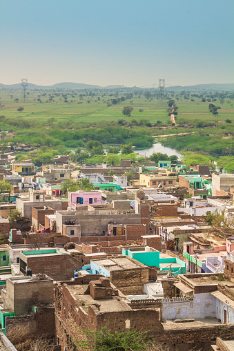 Flat plain of grassland and little Indian village in Rajasthan